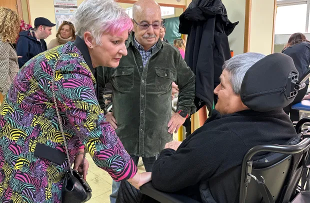 La delegada de la Junta saluda a personas usuarias de la asociación ADEMGU