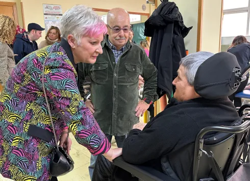 La delegada de la Junta saluda a personas usuarias de la asociación ADEMGU